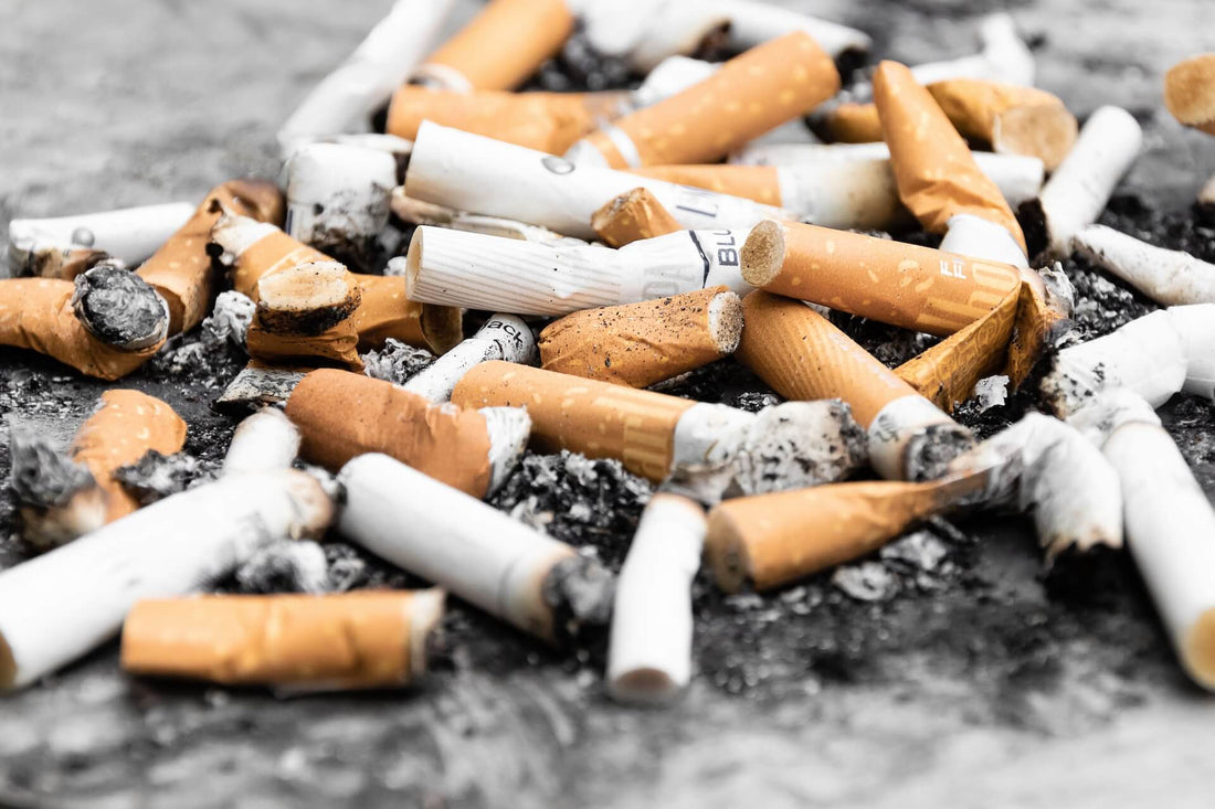 A pile of used cigarette butts mixed with ash